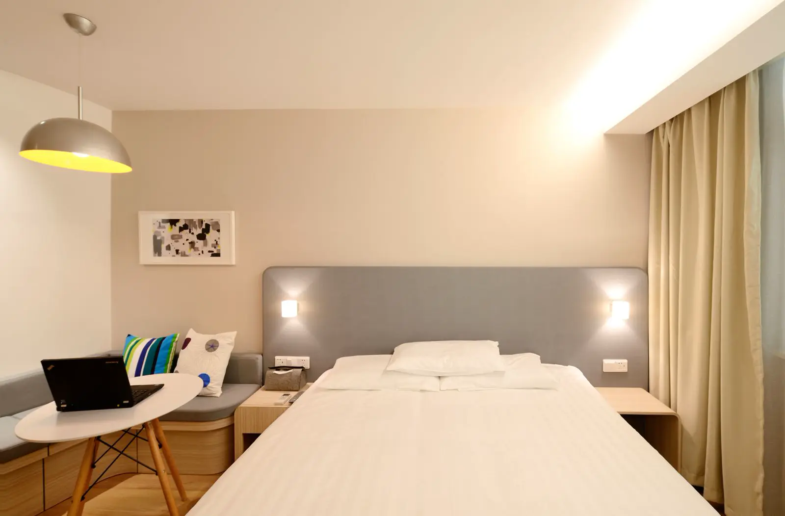 Simple hotel bedroom with carpet and dark furniture